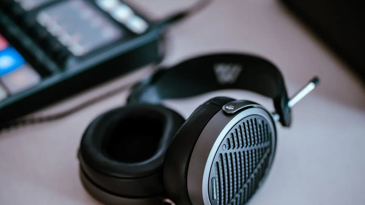 Wired headphones coiled on a desk next to a keyboard