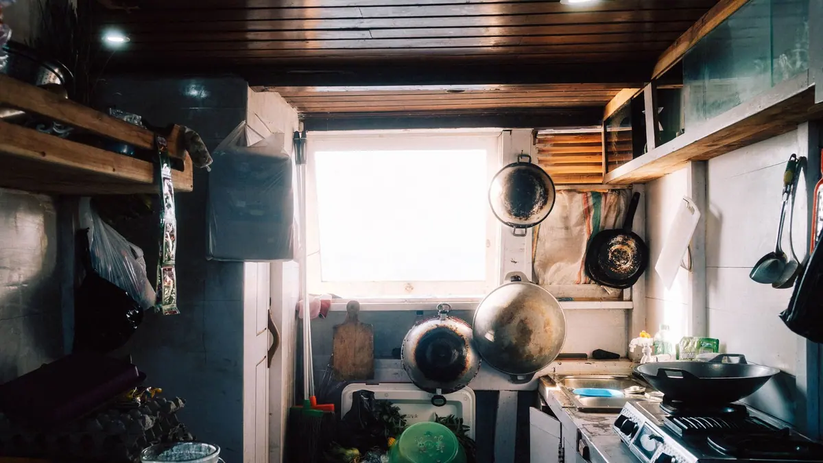 Pans hanging above a compact kitchen worktop
