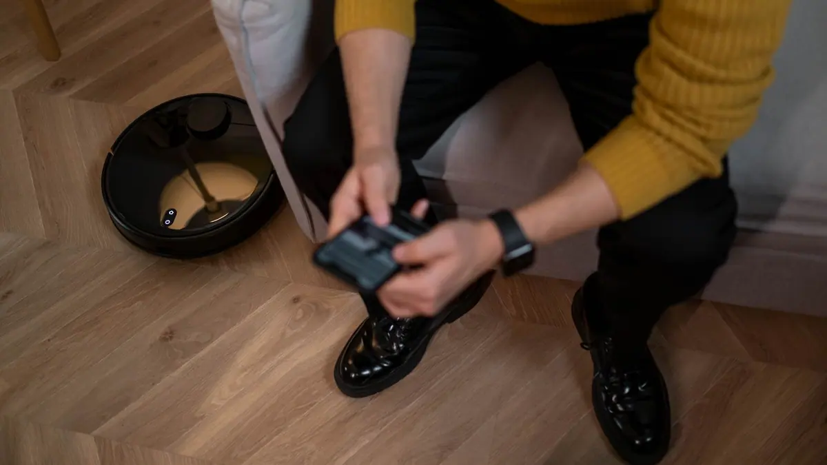 A robot vacuum cleaning a wooden living room floor