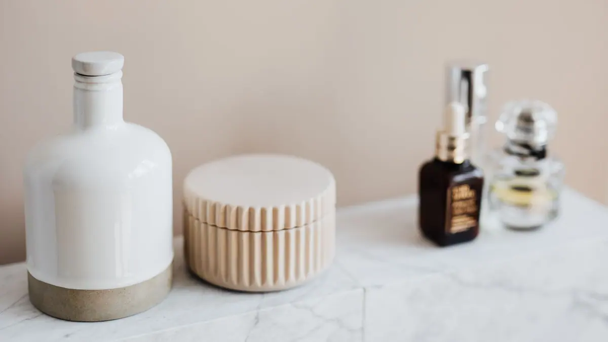 A small collection of skincare bottles on a bathroom shelf