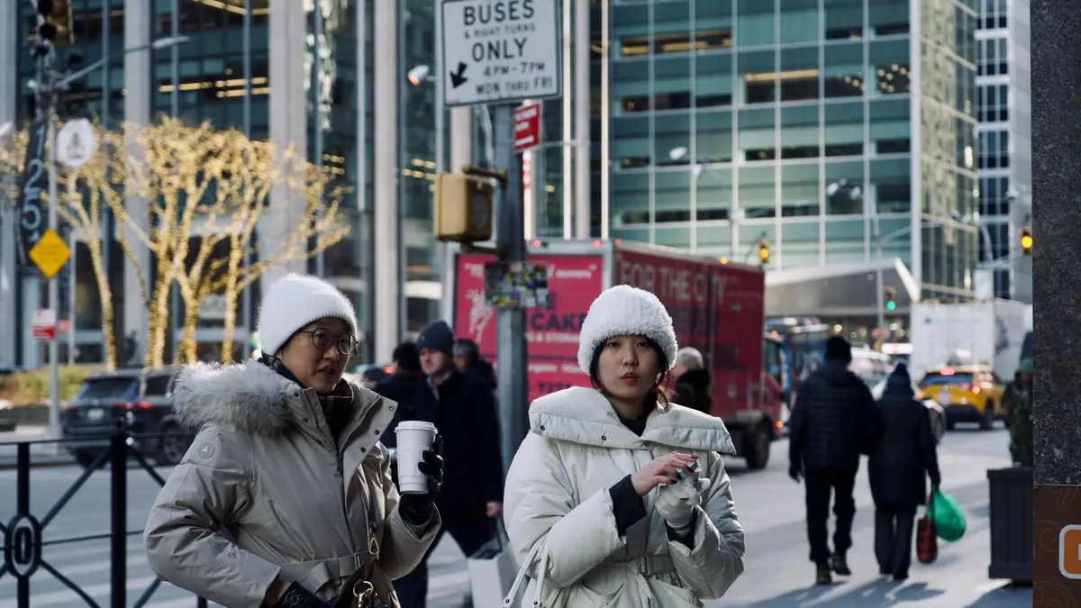 A person in a winter coat walking along a city street