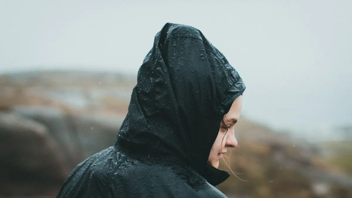A waterproof jacket hanging on a hook with rain on the shoulders