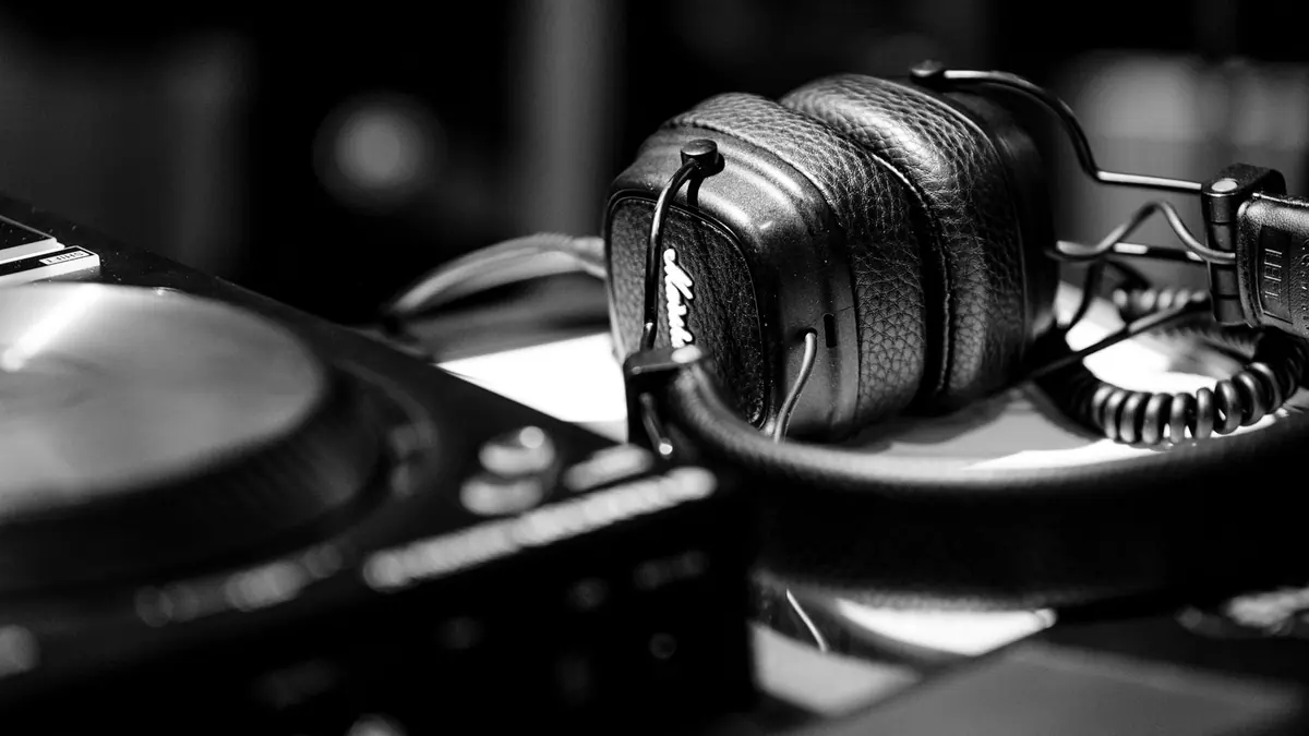 A pair of headphones with a detachable cable unplugged beside them