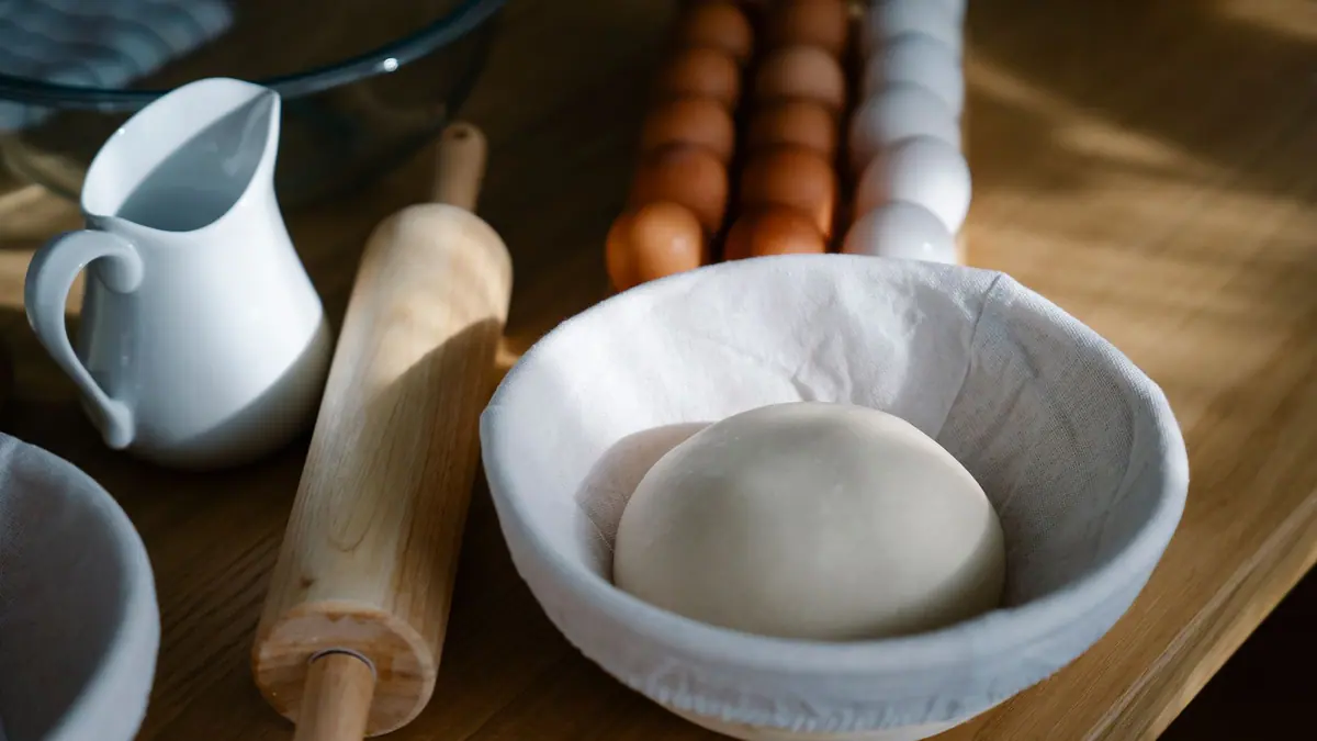 Dough being kneaded in a stand mixer bowl