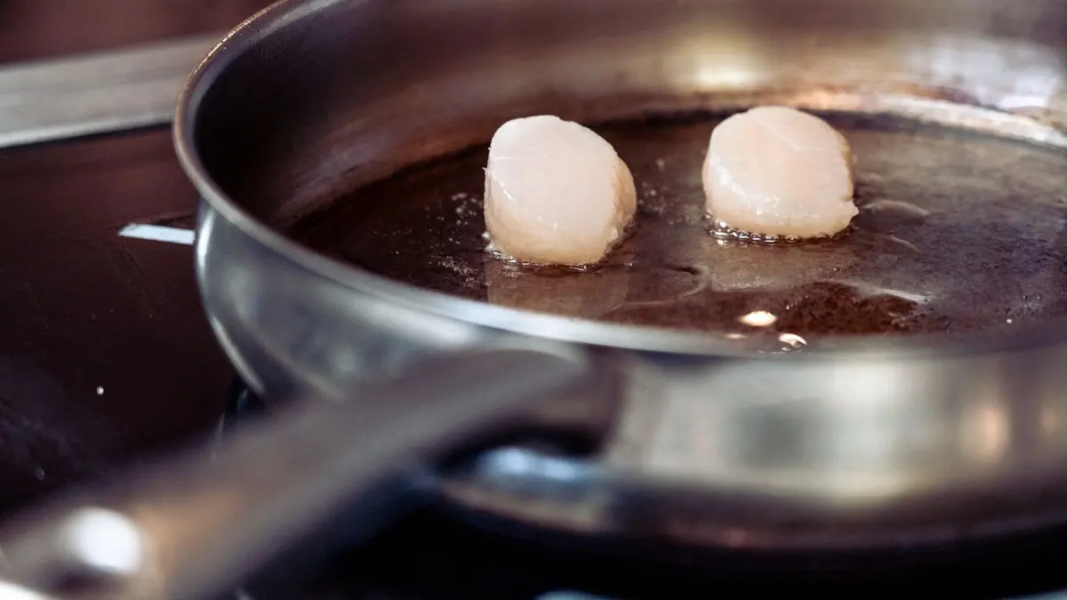 A stainless steel pan on a compact hob