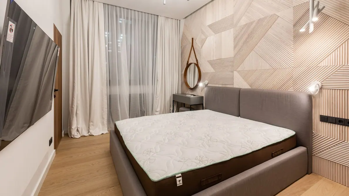 A rolled mattress being unpacked in a bedroom