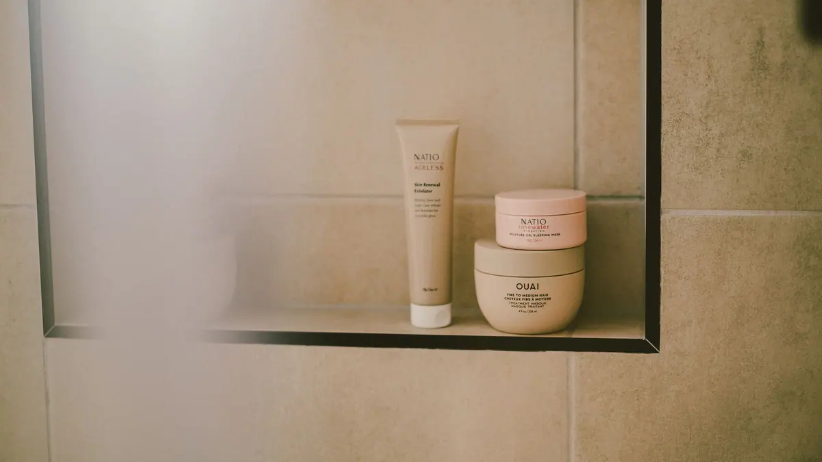 Several sunscreen products arranged on a bathroom shelf