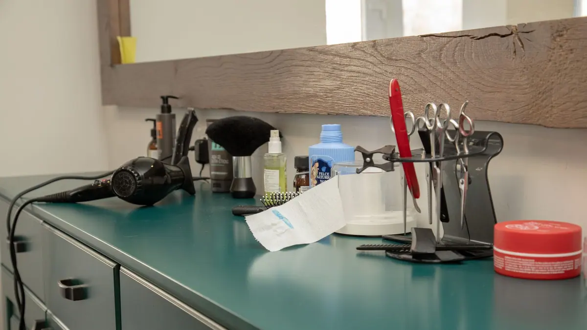 A hair dryer and round brush on a bathroom counter