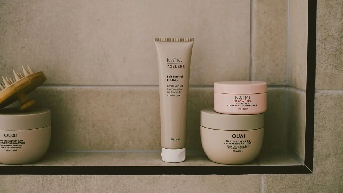 A small number of skincare products on a clean bathroom shelf