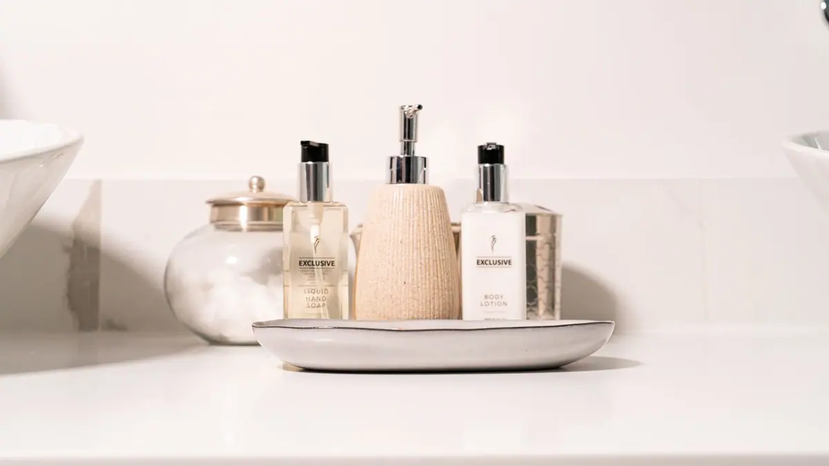 Skincare products arranged beside a bathroom sink