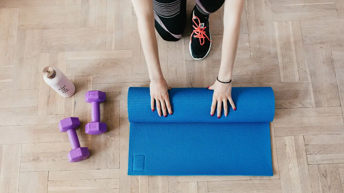 Adjustable dumbbells and a mat in a home setting