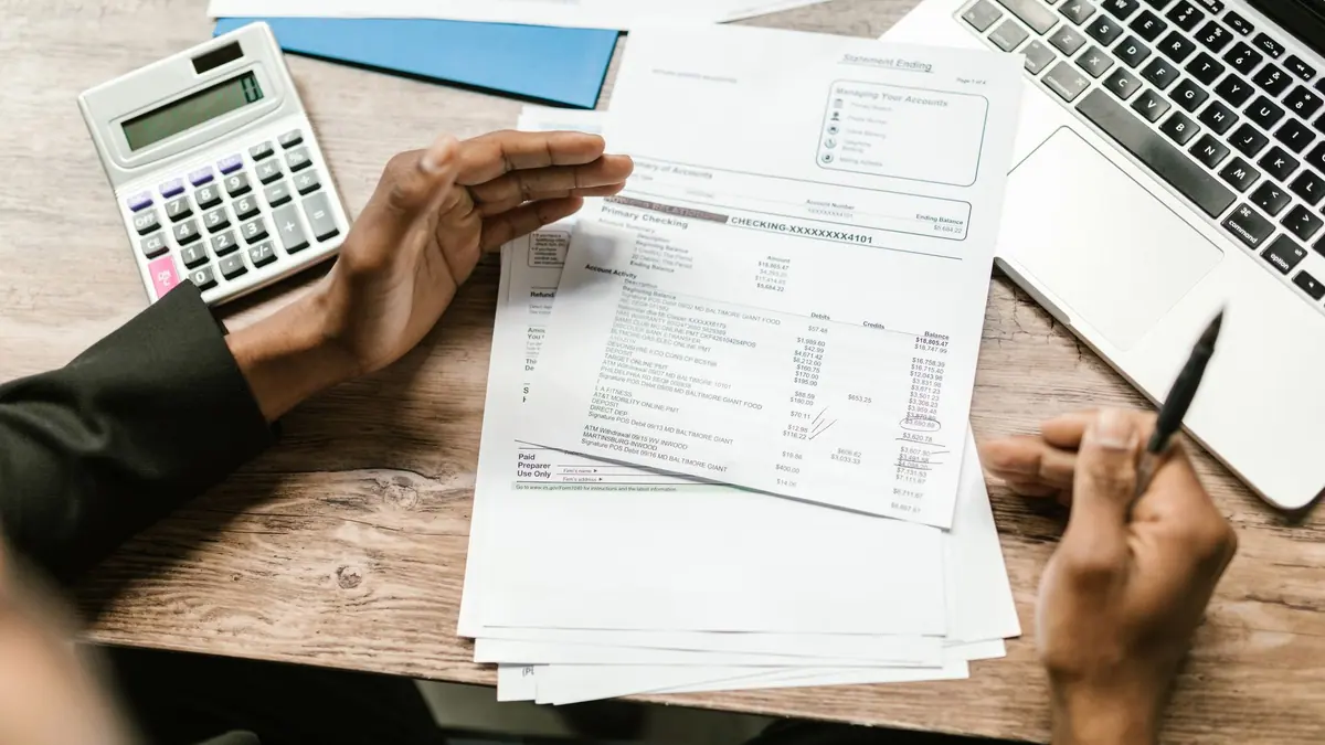 A bank statement and calculator on a desk