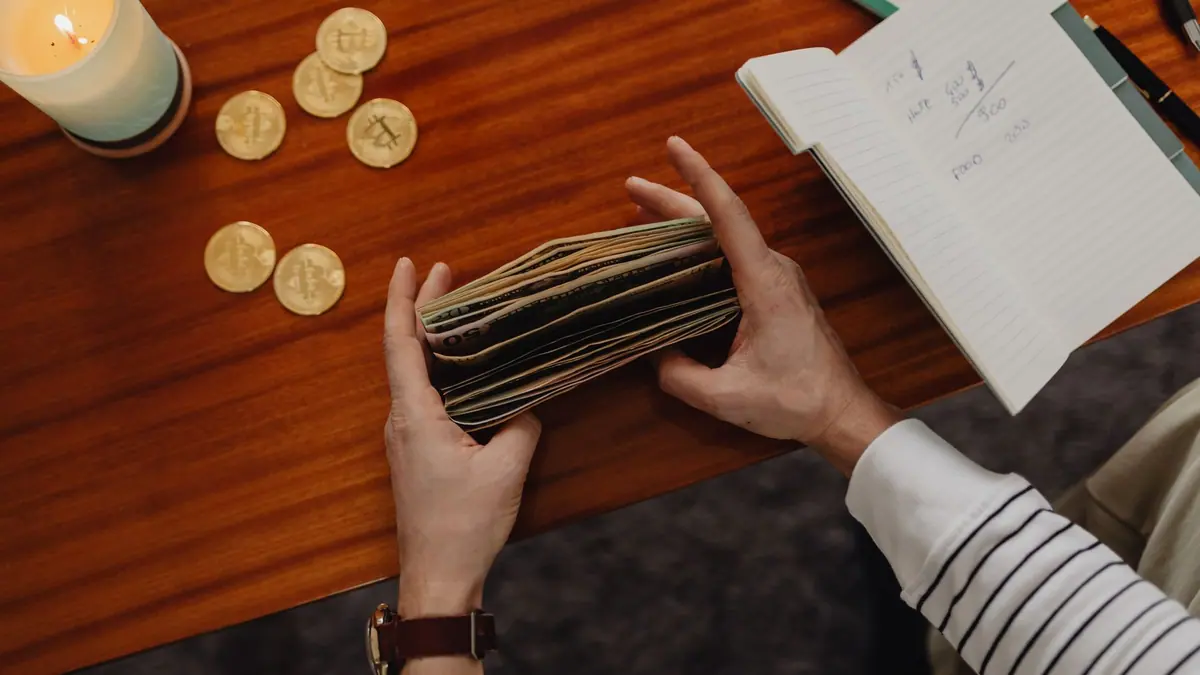 Coins and a notebook on a wooden table