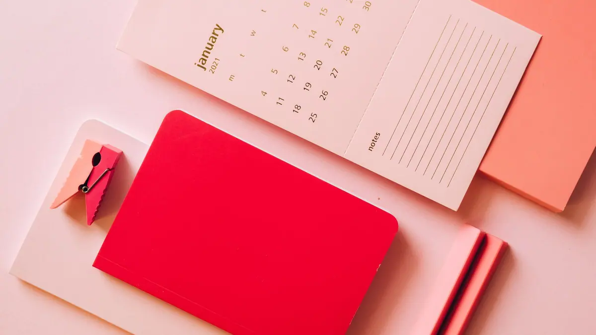 A calendar and notebook on a desk